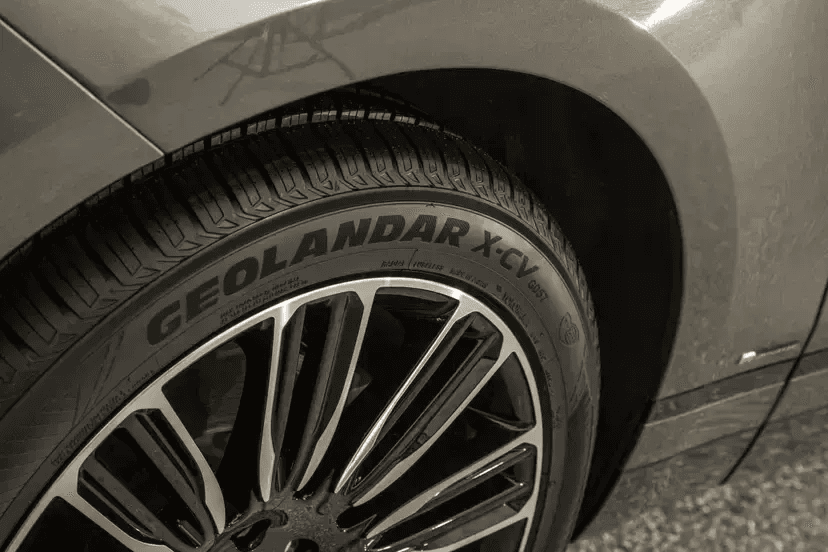 Primer plano de una llanta Yokohama Geolandar X-CV montada en una SUV de lujo.