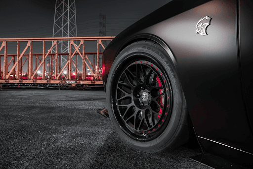 Detalle de llanta Yokohama ADVAN Apex V601 en auto deportivo negro, con rin multirradio negro y acen