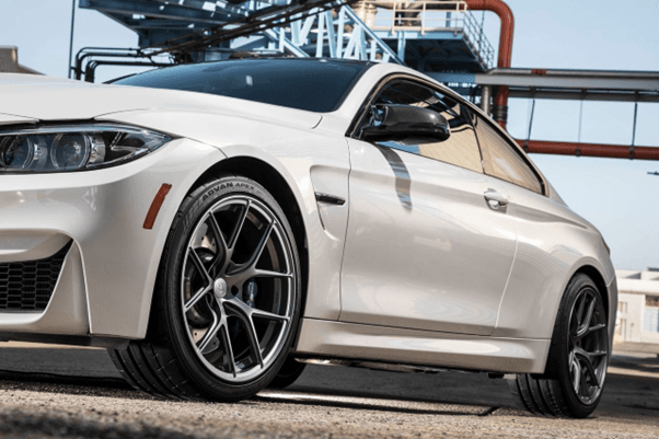 Primer plano de la parte frontal de un BMW M4 blanco con llantas deportivas y neumáticos Yokohama AD