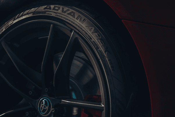 Acercamiento artístico al neumático Yokohama ADVAN Apex montado en un deportivo rojo, con el logotip