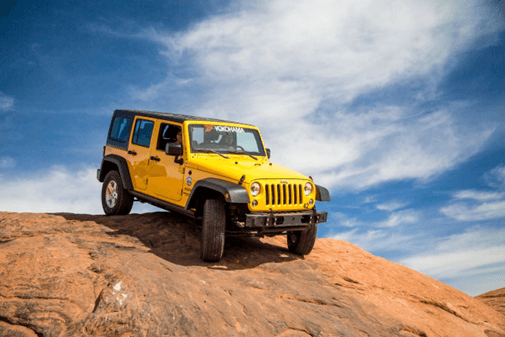 Jeep todoterreno amarillo con llantas Yokohama en terreno rocoso.
