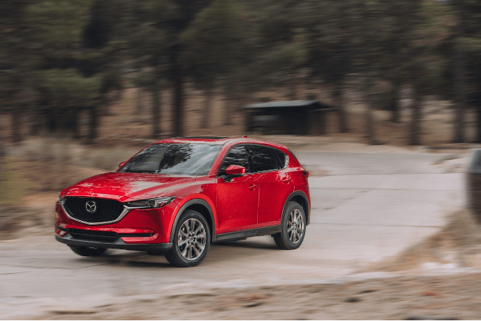 SUV Mazda CX-5 en carretera de bosque equipado con llantas Yokohama Geolandar. 