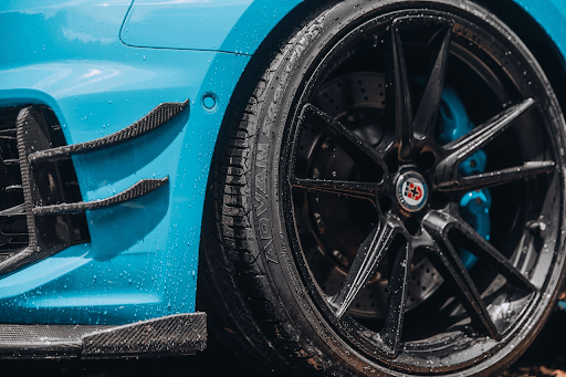 Detalle de llanta deportiva Yokohama Advan Sport V107 en vehículo azul de alto desempeño, diseñada p