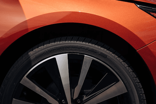 Neumático Yokohama AVID Ascend GT instalado en sedán color naranja, diseñado para alto kilometraje y