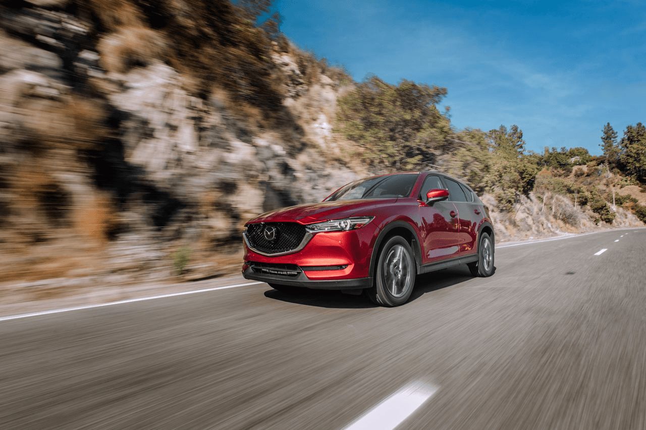 Mazda CX-5 en movimiento sobre una carretera de montaña, equipado con neumáticos Yokohama Geolandar 