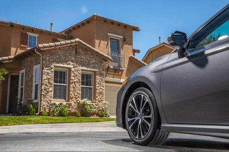 Llantas Yokohama AVID Ascend LX en un auto estacionado frente a una casa de estilo residencial con c