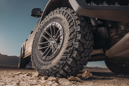 Llanta Yokohama Geolandar M/T G003 en terreno seco montada en una Ford Raptor, vista de cerca mostra