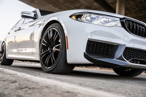 Llanta Yokohama ADVAN Apex montada en BMW deportivo sobre pavimento seco.